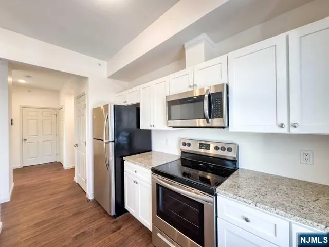 a kitchen with stainless steel appliances granite countertop a stove a microwave and a refrigerator