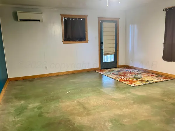 a view of an empty room with window and fireplace