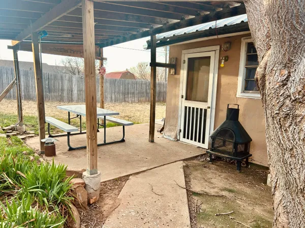 a backyard of a house with table and chairs