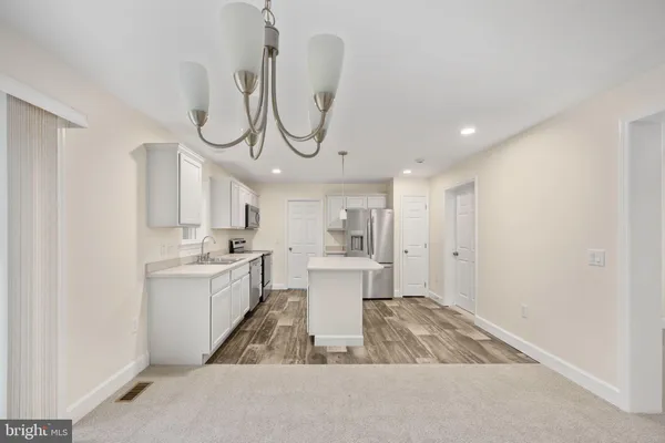 a kitchen with a sink a counter space and wooden floor