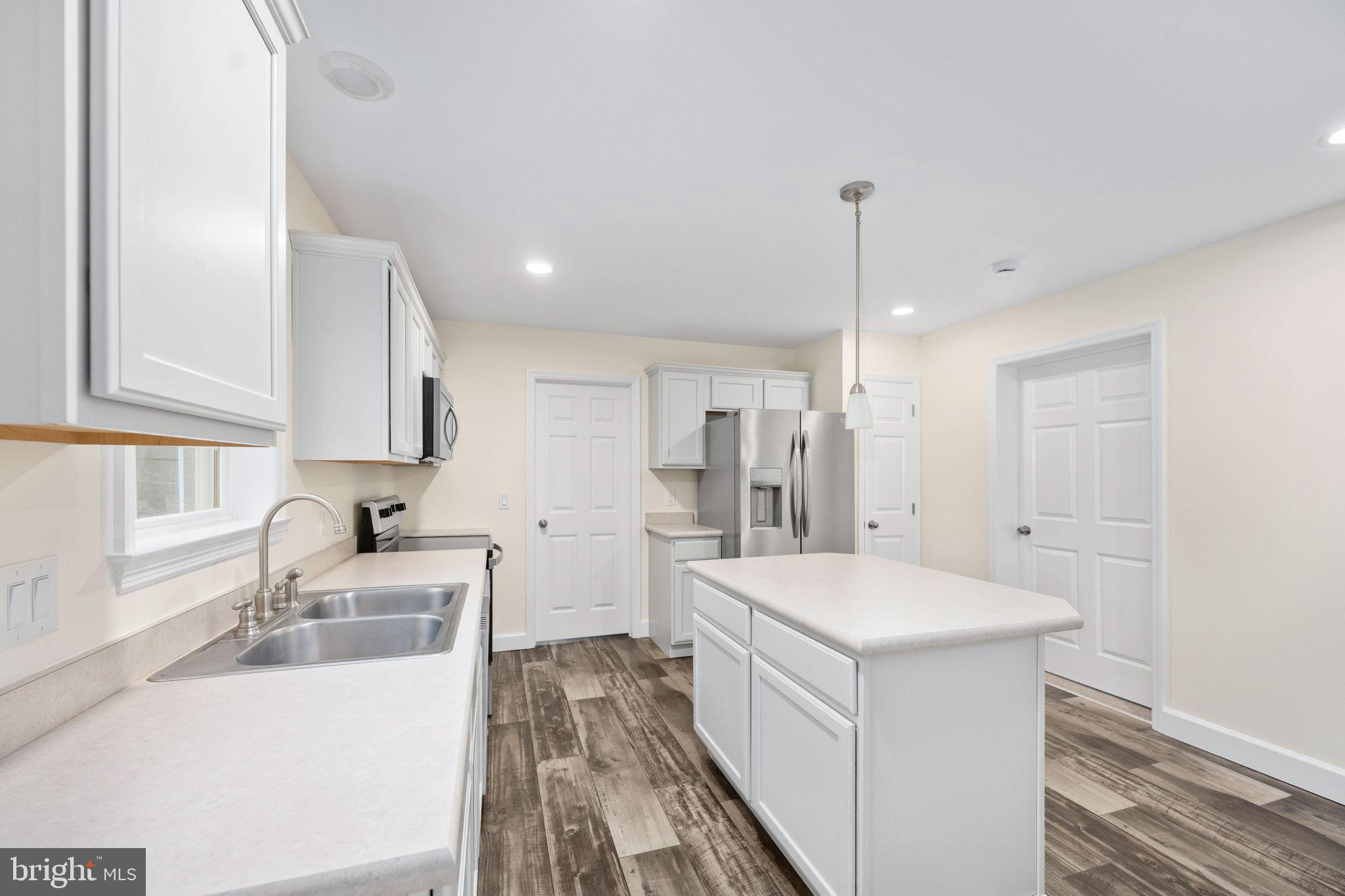 300 River Oaks Road Center Cross, VA 22437 - Photo 21 of 39 a large white kitchen with sink refrigerator and cabinets