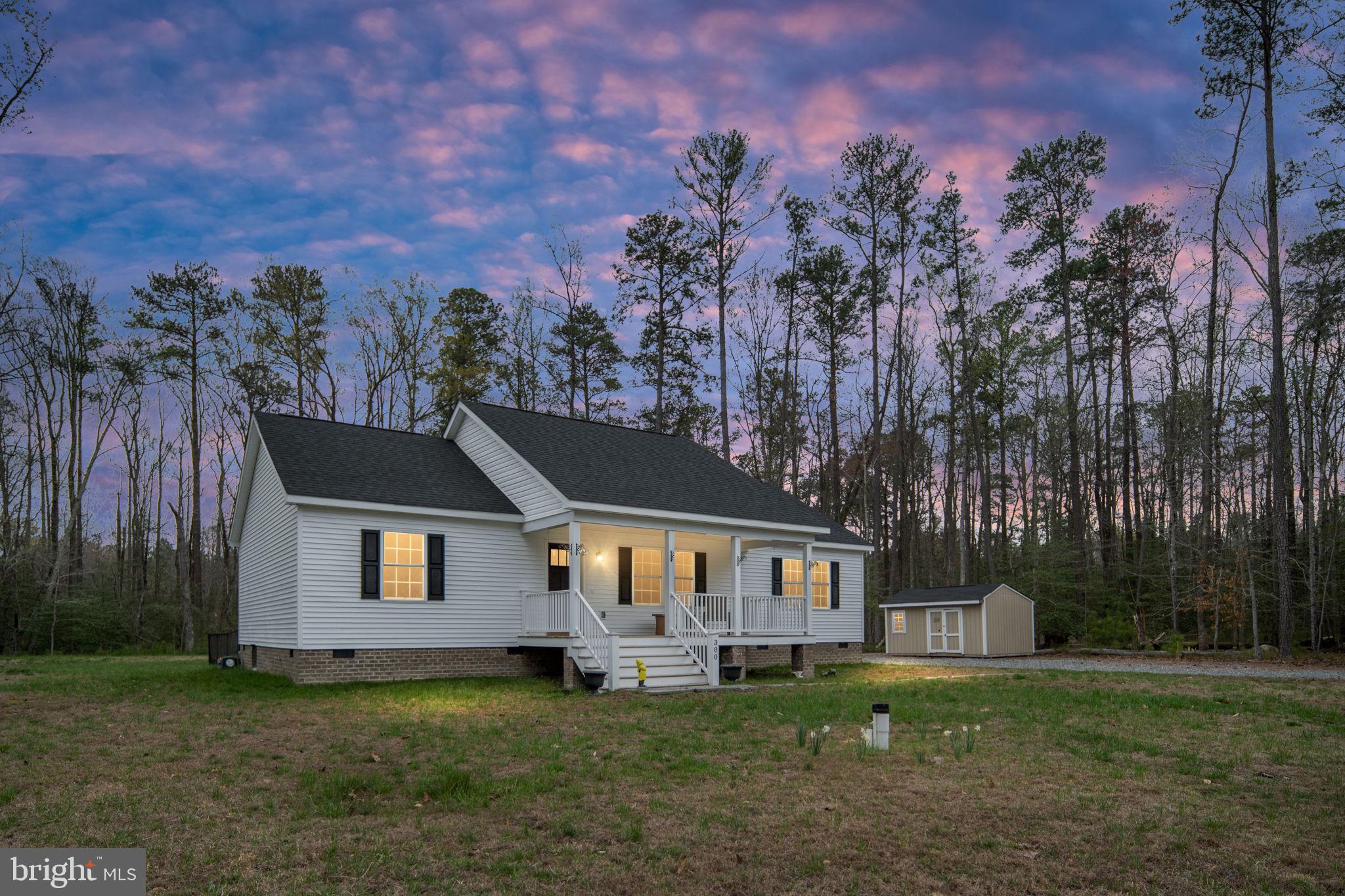 300 River Oaks Road Center Cross, VA 22437 - Photo 3 of 39 a front view of a house with a garden and trees