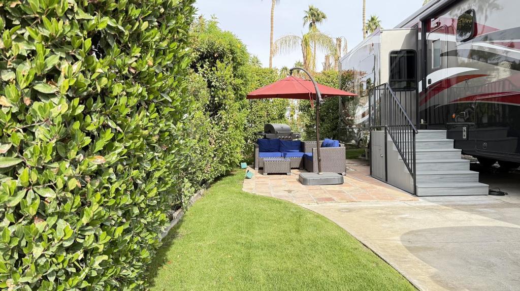 69411 Ramon Road, Unit 91 Cathedral City, CA 92234 - Photo 2 of 9 a view of a patio with a table and chairs under an umbrella