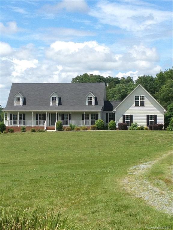 a aerial view of a house next to a big yard and large trees