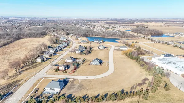 an aerial view of a house with a yard and mountain view in back
