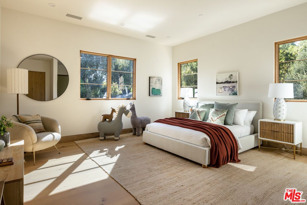 24877 Eldorado Meadow Road Hidden Hills, CA 91302 - Photo 31 of 46 a spacious bedroom with a bed and wooden floor
