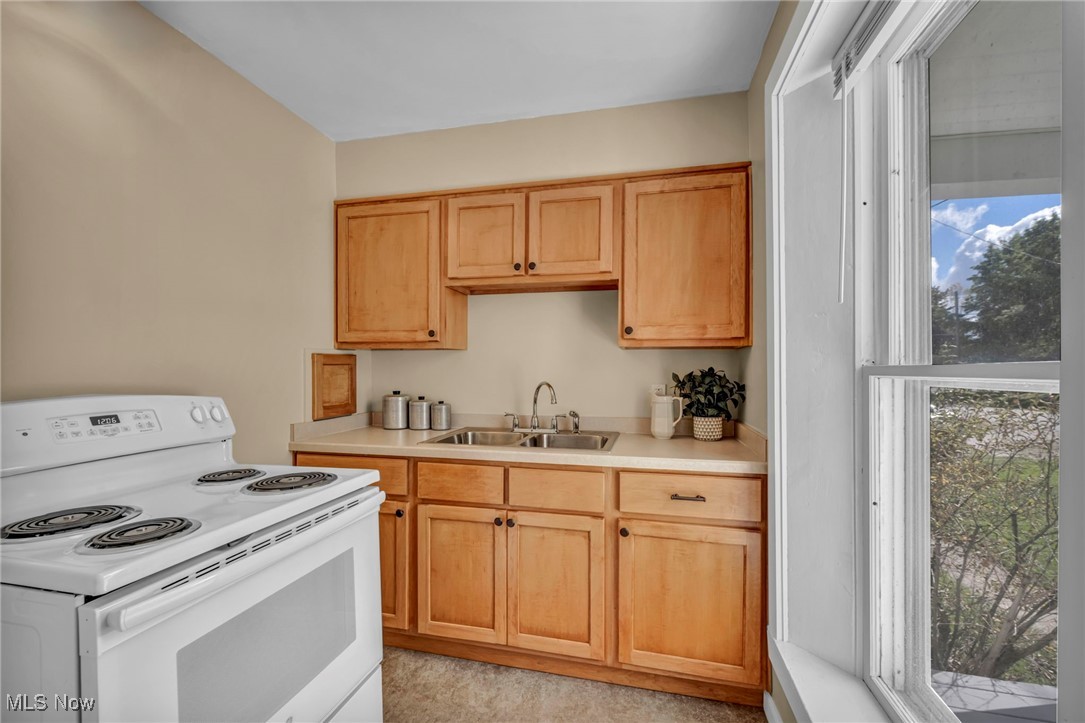5639 Trumbull Road Geneva, OH 44041 - Photo 12 of 35 Kitchen featuring white range with electric cooktop, light countertops, and light brown cabinets