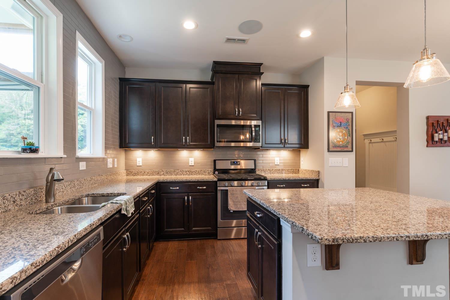 3565 Massey Ridge Court Raleigh, NC 27616 - Photo 12 of 22 a kitchen with stainless steel appliances granite countertop wooden cabinets a sink and a stove