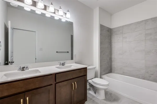 a bathroom with a sink a toilet a mirror and shower