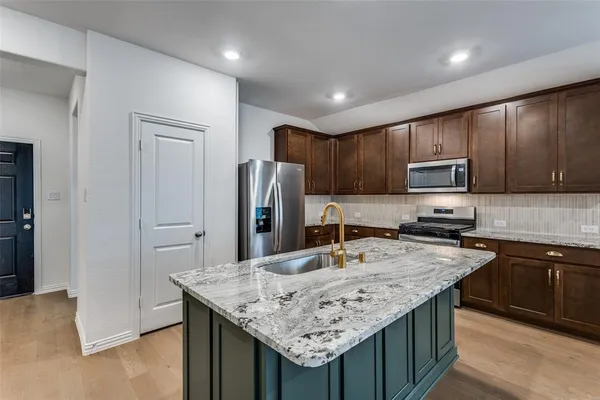 a kitchen with granite countertop kitchen island cabinets stainless steel appliances and wooden cabinets