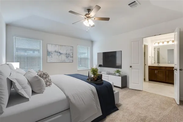 a bedroom with a bed a couches and a flat screen tv