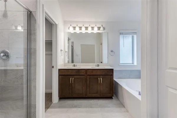 a spacious bathroom with a bathtub sink and mirror