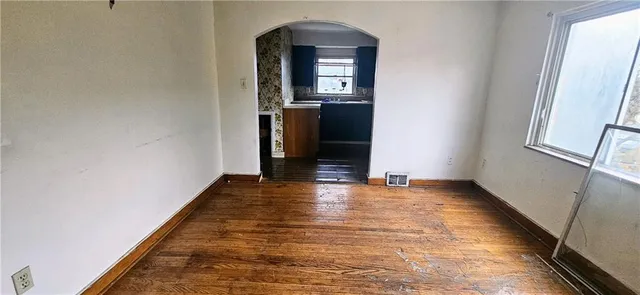 a kitchen with a refrigerator a stove a sink and wooden floor
