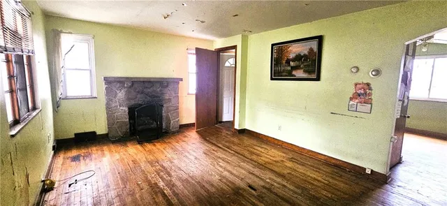 a view of an empty room with a fireplace and a window