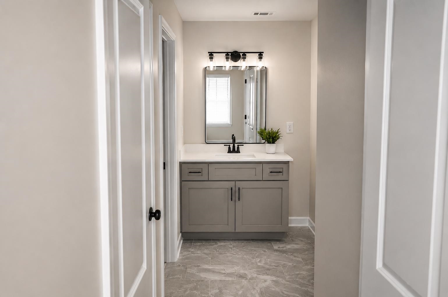 1687 East Alcy Road Memphis, TN 38114 - Photo 4 of 7 Bathroom vanity featuring a quartz countertop, integrated sink, and gray cabinetry with matte black hardware