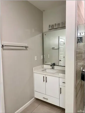 a bathroom with a granite countertop sink and a mirror