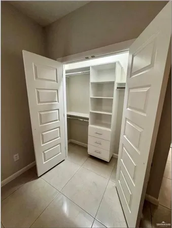 a view of walk in closet with empty racks