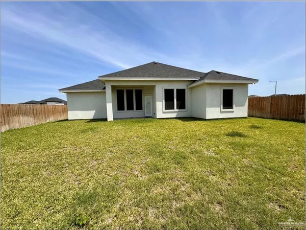 a front view of a house with yard and trees