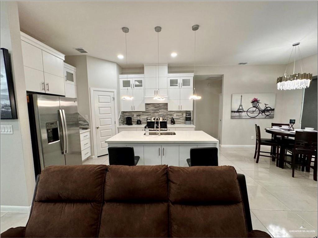 3120 East Rabbit Run Avenue Alton, TX 78573 - Photo 4 of 21 a kitchen with a refrigerator and a dining table