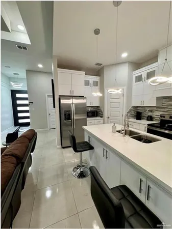 a kitchen with refrigerator and chairs
