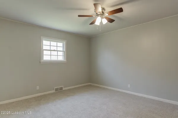 an empty room with a window and a fan