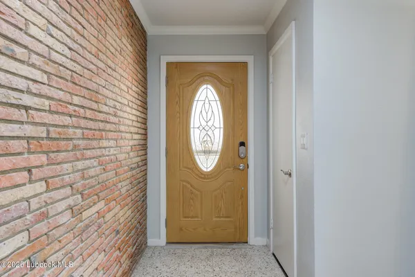 a view of a entryway door with brick walls