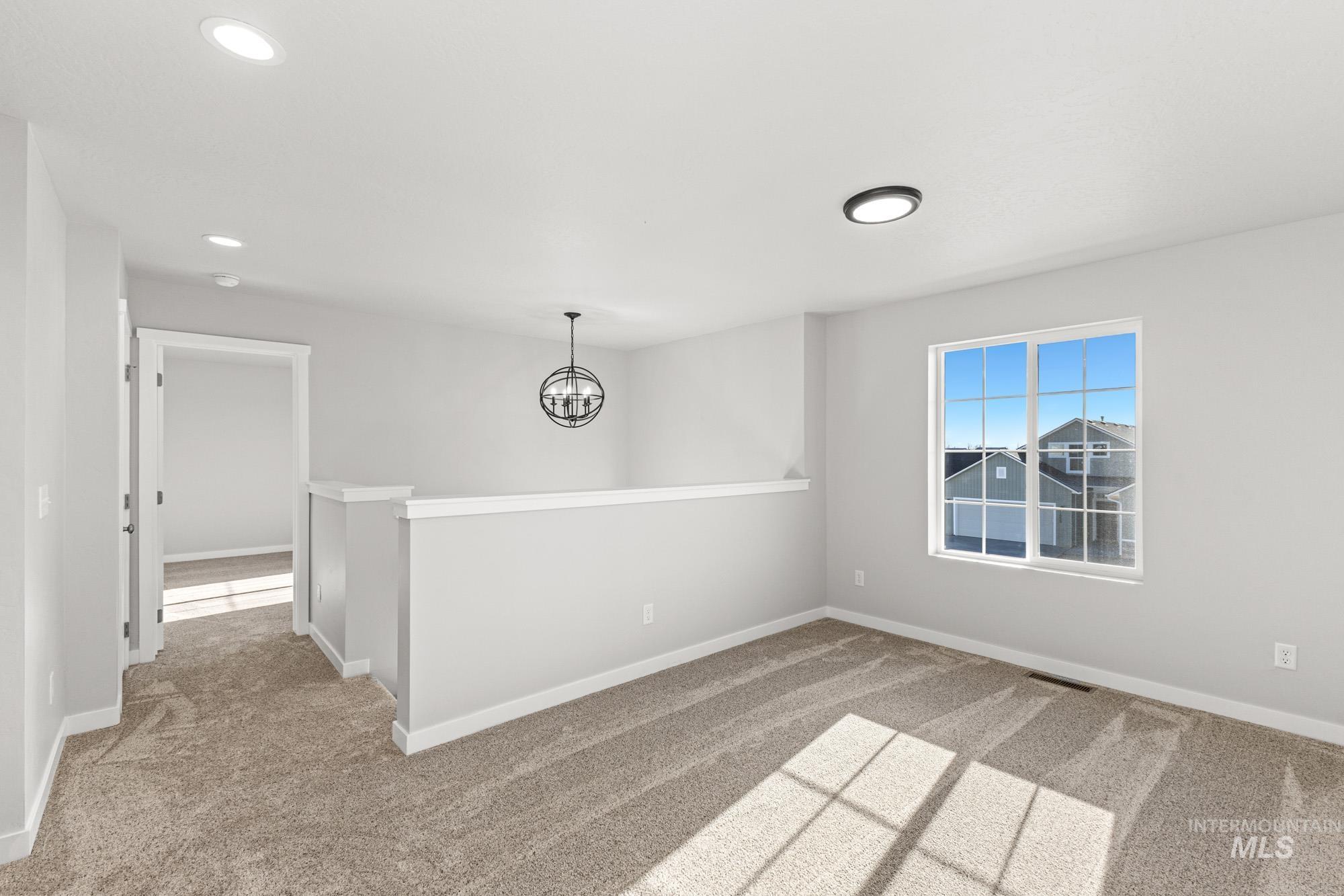 1436 Long Pond Street Middleton, ID 83644 - Photo 11 of 24 Spare room with light colored carpet, a chandelier, and recessed lighting