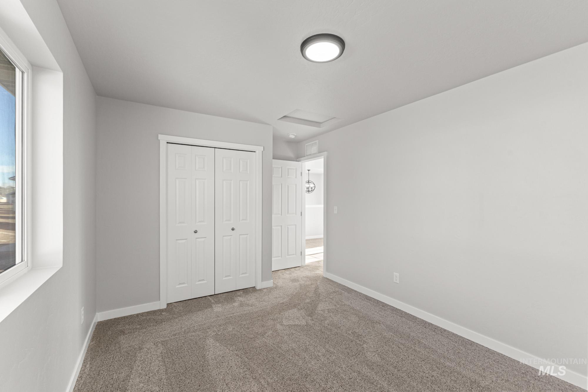 1436 Long Pond Street Middleton, ID 83644 - Photo 15 of 24 Unfurnished bedroom featuring attic access, carpet, and a closet