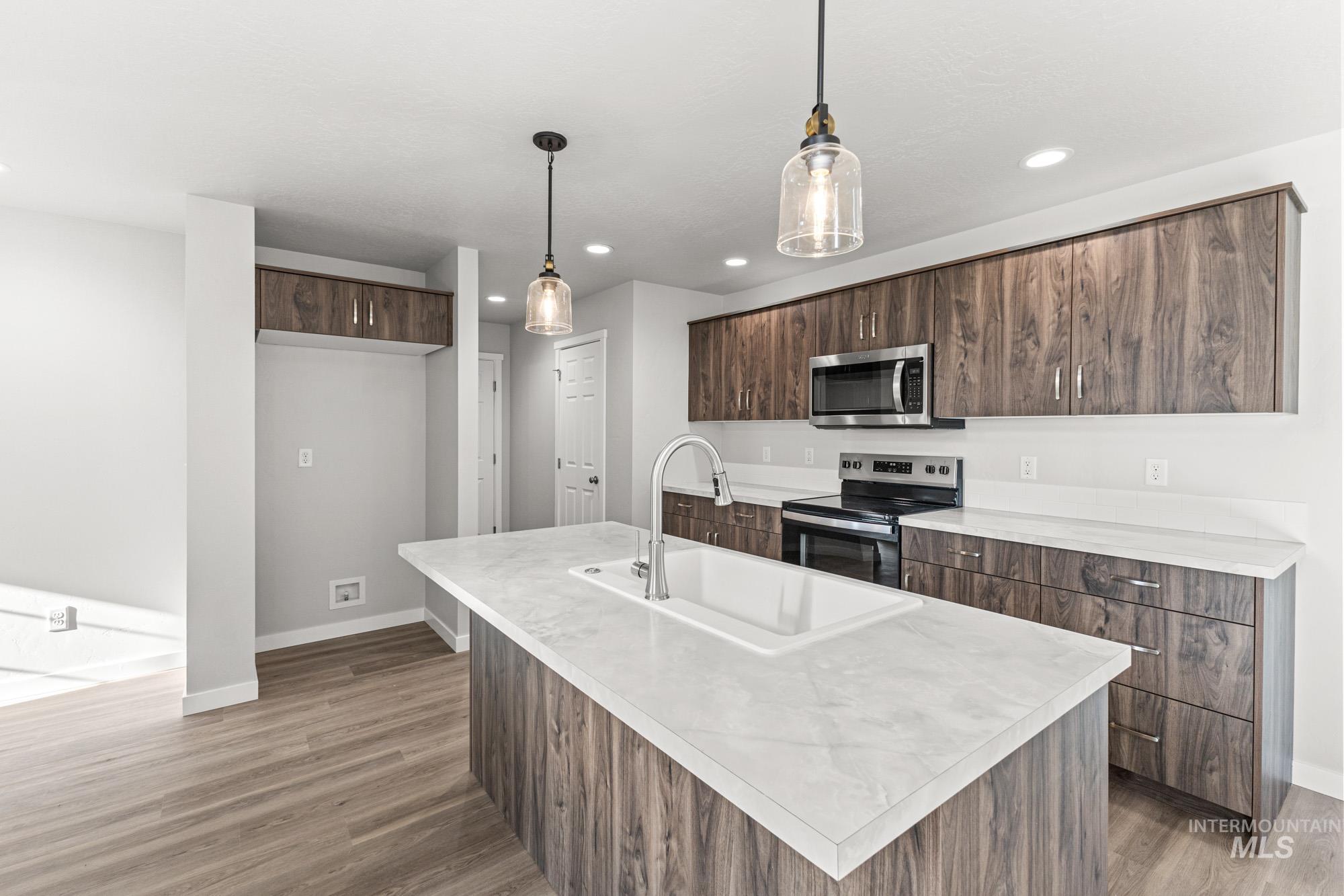 1436 Long Pond Street Middleton, ID 83644 - Photo 5 of 24 Kitchen featuring modern cabinets, light countertops, appliances with stainless steel finishes, pendant lighting, and recessed lighting