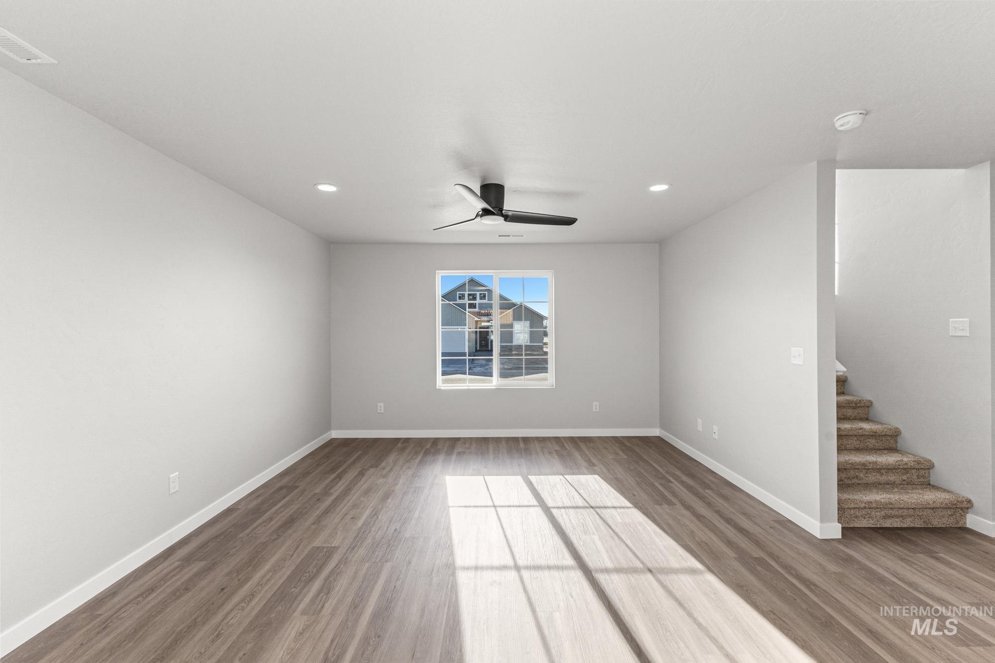 1436 Long Pond Street Middleton, ID 83644 - Photo 8 of 24 Empty room with stairs, ceiling fan, light wood-style floors, and recessed lighting