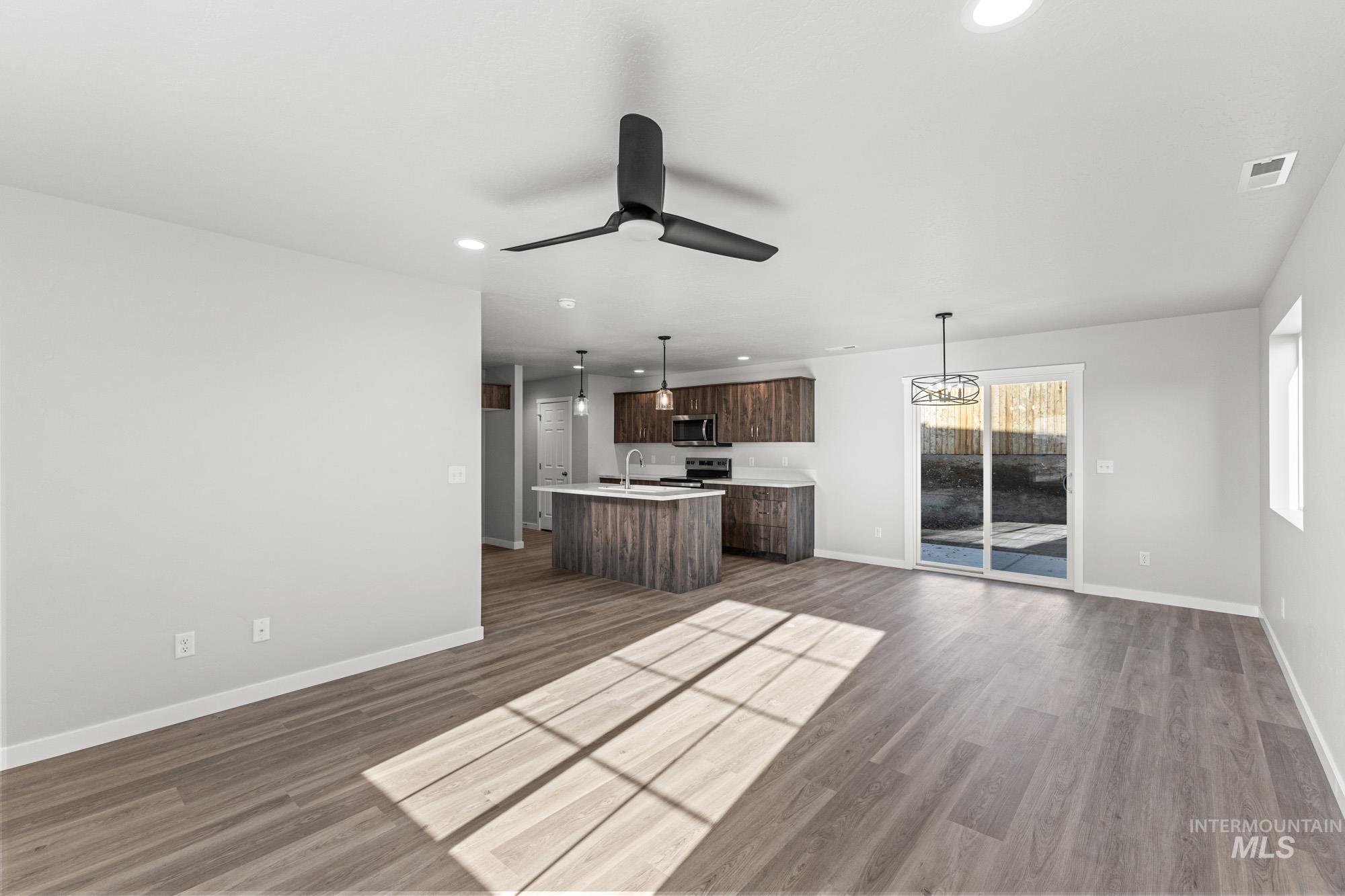 1436 Long Pond Street Middleton, ID 83644 - Photo 24 of 24 Kitchen featuring light countertops, open floor plan, recessed lighting, dark brown cabinetry, and hanging light fixtures