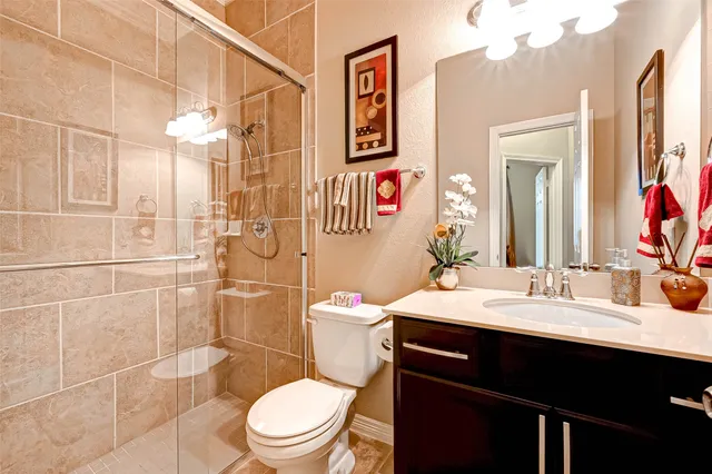 a bathroom with a sink a toilet and shower