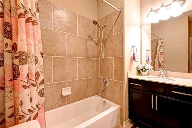 a bathroom with a sink and mirror with bathtub