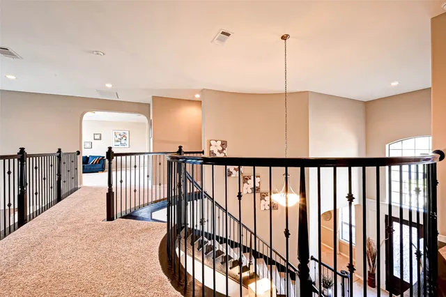 a view of staircase with railing and a chandelier