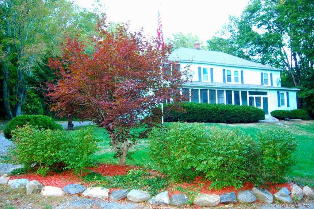 a view of a house with a yard and potted plants