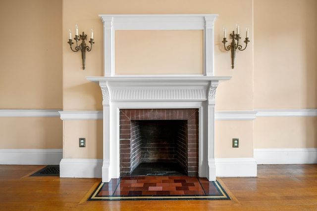a view of empty room with wooden floor and fireplace