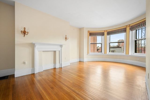 a view of a brick house with a small yard and plants