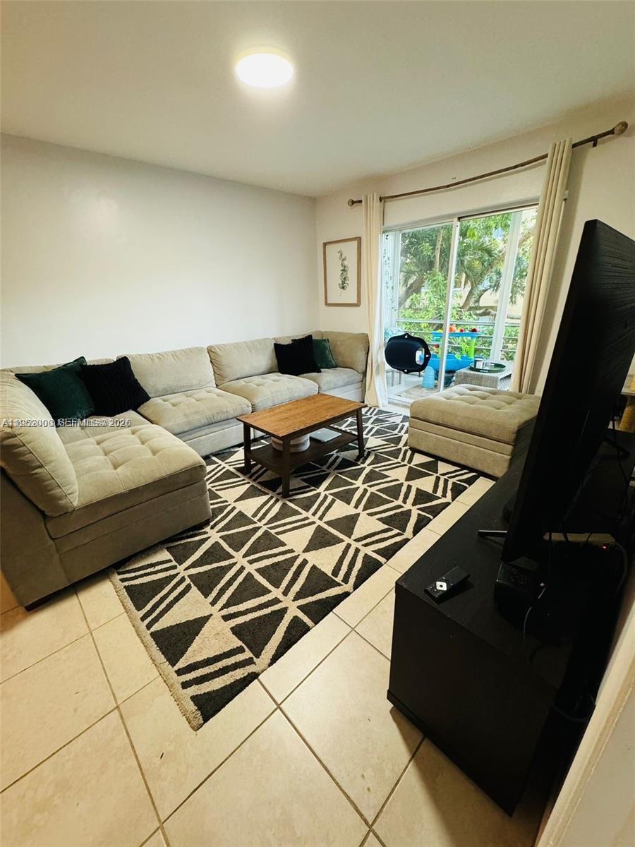 4111 Stirling Road, Unit 308 Fort Lauderdale, FL 33314 - Photo 12 of 32 a living room with furniture and a floor to ceiling window