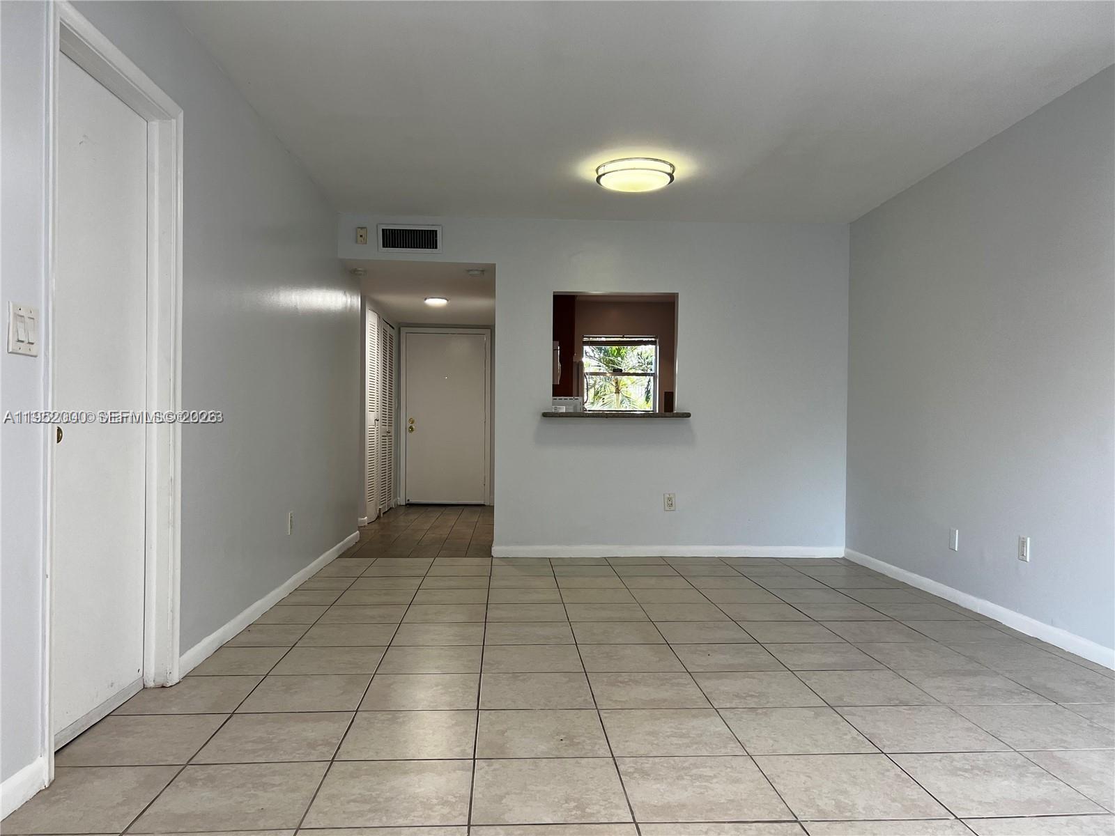 4111 Stirling Road, Unit 308 Fort Lauderdale, FL 33314 - Photo 13 of 32 a view of an empty room and a bathroom with mirror