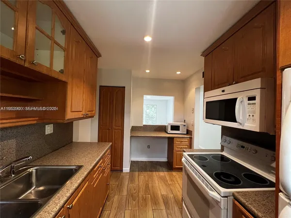 a kitchen that has a sink and a stove top oven