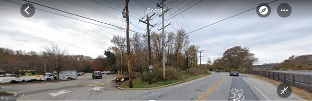 a view of a patio with a table and chairs couches under an umbrella with a small yard