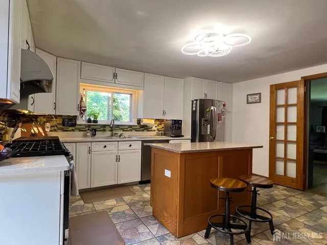a kitchen with a stove a table and chairs in it