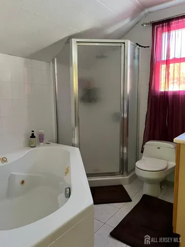 a bathroom with a sink a toilet a window and shower