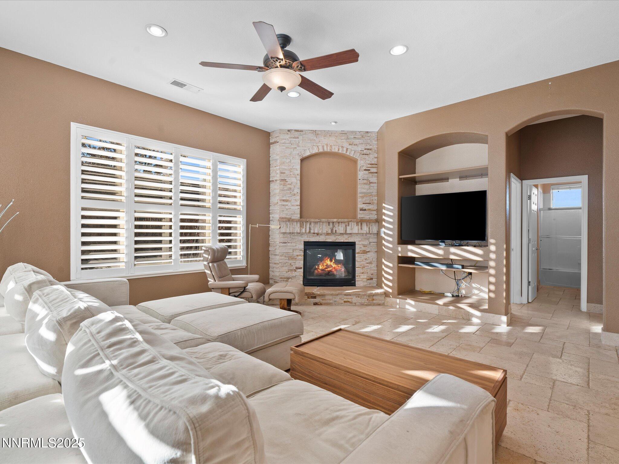 5519 New Mexico Court Reno, NV 89511 - Photo 12 of 60 a spacious bedroom with a large bed a flat screen tv and a fireplace