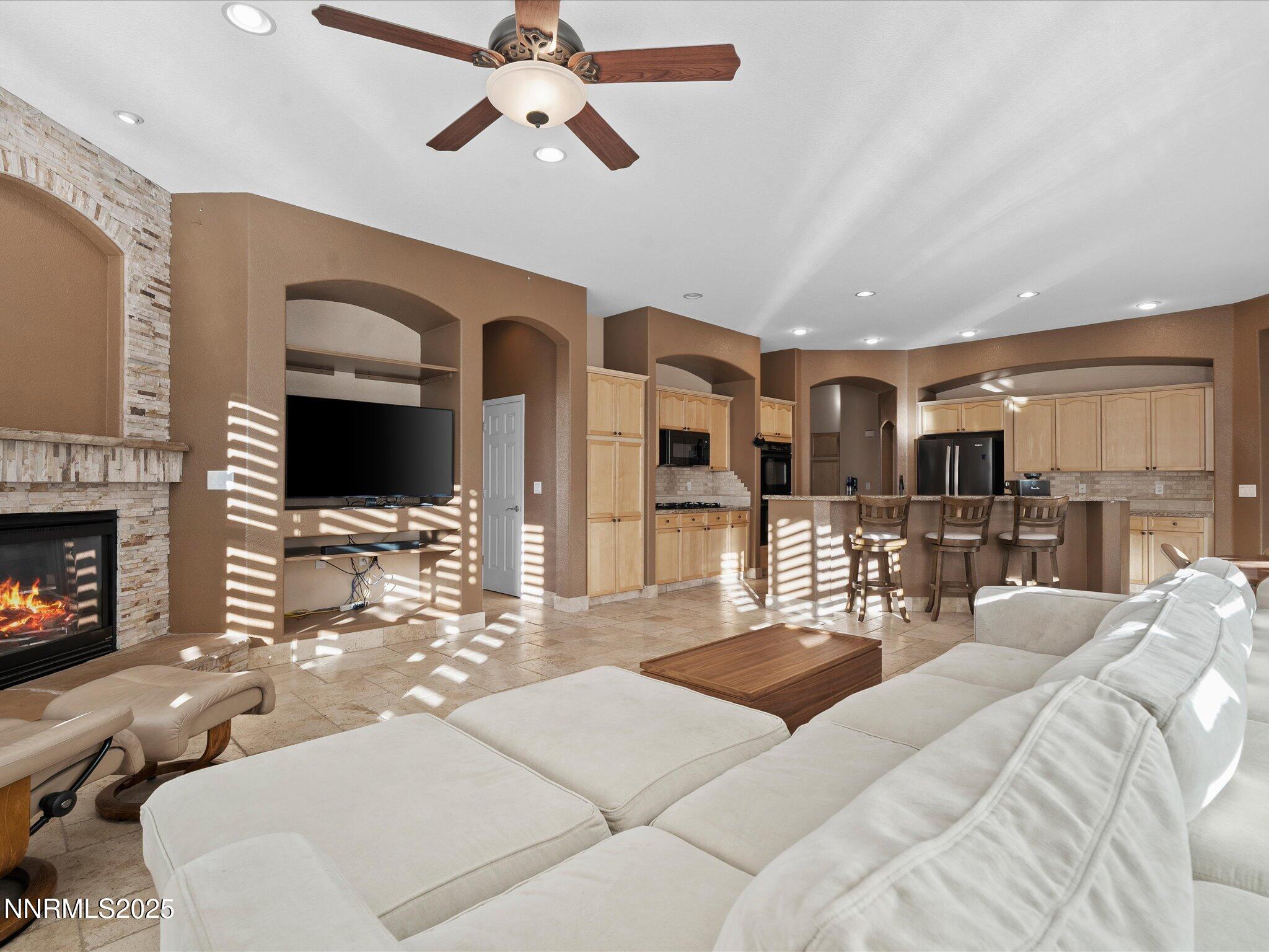 5519 New Mexico Court Reno, NV 89511 - Photo 13 of 60 a living room with furniture a fireplace and a flat screen tv