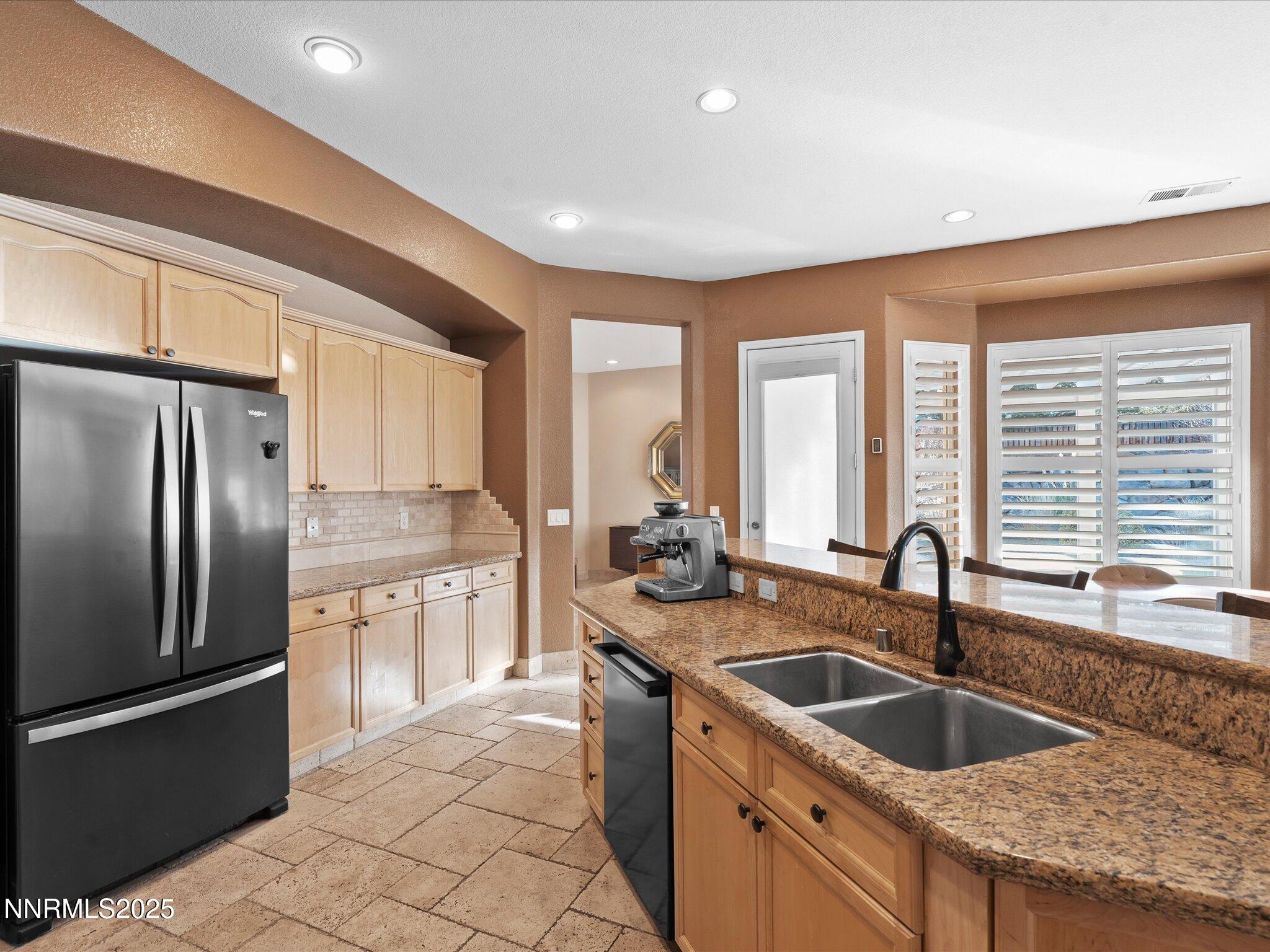 5519 New Mexico Court Reno, NV 89511 - Photo 23 of 60 a kitchen with granite countertop a sink and a refrigerator