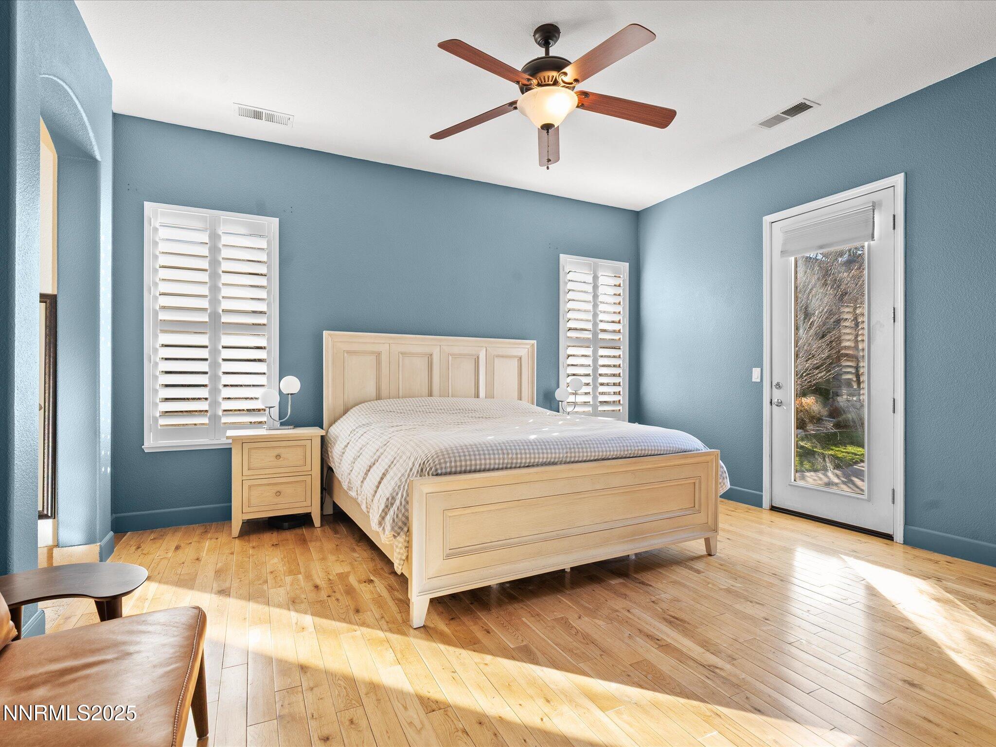5519 New Mexico Court Reno, NV 89511 - Photo 24 of 60 a spacious bedroom with a large bed a chandelier and windows