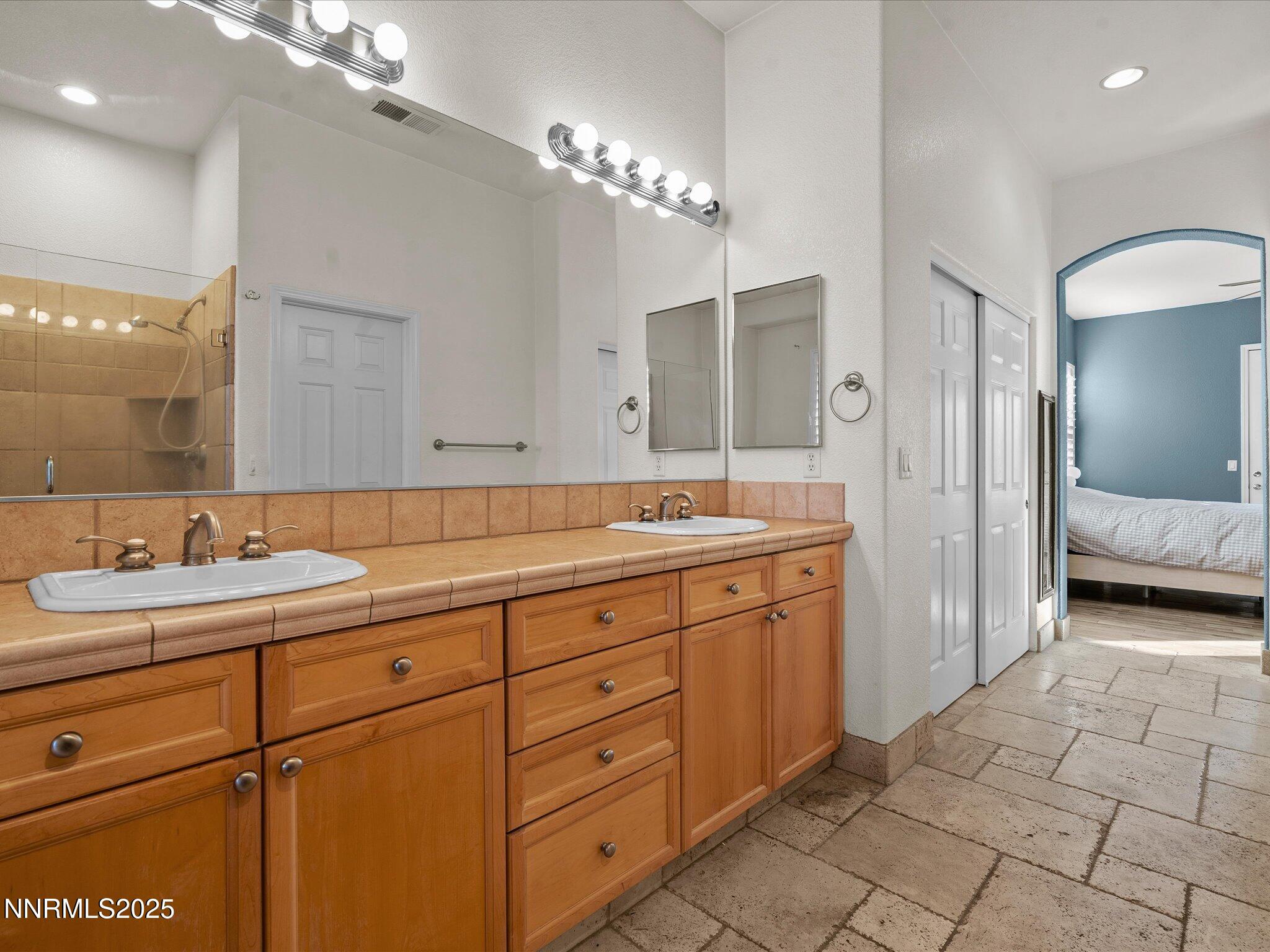 5519 New Mexico Court Reno, NV 89511 - Photo 30 of 60 a spacious bathroom with a double vanity sink a mirror and shower