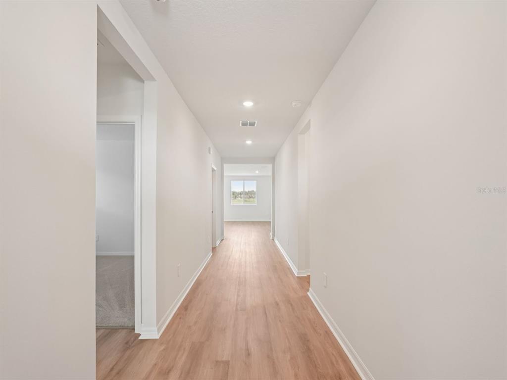 7722 Satterfield Terrace Parrish, FL 34219 - Photo 2 of 22 a view of a hallway with wooden floor