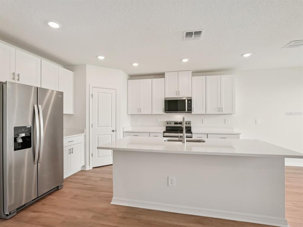 7722 Satterfield Terrace Parrish, FL 34219 - Photo 7 of 22 a kitchen with stainless steel appliances a refrigerator sink and microwave